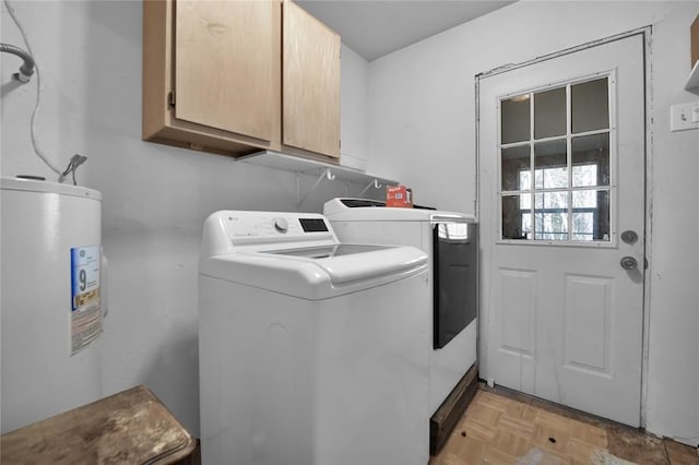 clothes washing area with light parquet flooring, washer and dryer, cabinets, and electric water heater