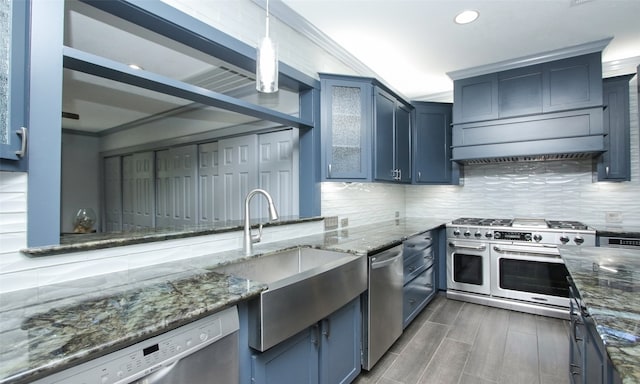 kitchen with appliances with stainless steel finishes, decorative light fixtures, backsplash, and dark stone countertops