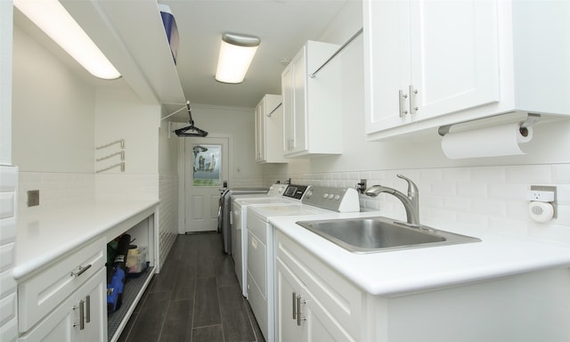 laundry room featuring washer and dryer, cabinets, sink, and dark hardwood / wood-style flooring