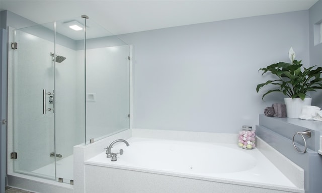 bathroom featuring shower with separate bathtub