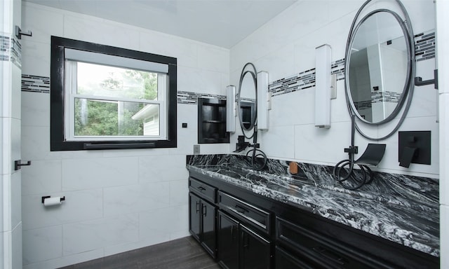 bathroom with tile walls, hardwood / wood-style flooring, and large vanity