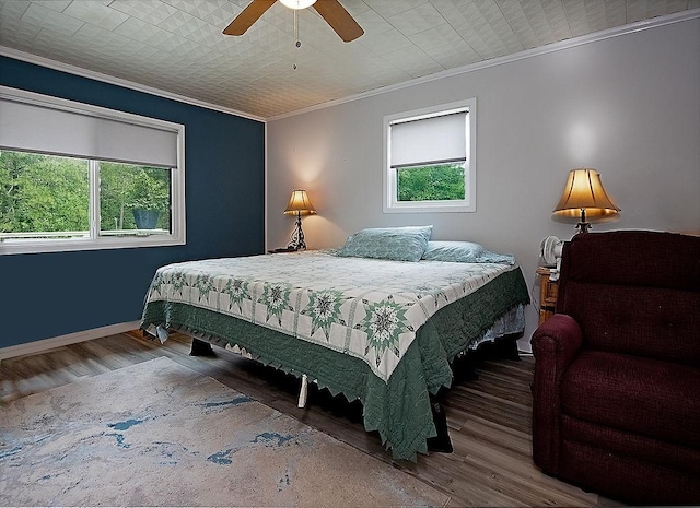 bedroom featuring wood-type flooring, ornamental molding, and ceiling fan