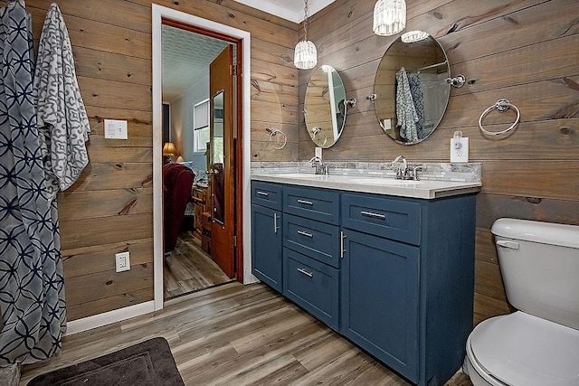 bathroom featuring vanity, hardwood / wood-style floors, toilet, and wood walls