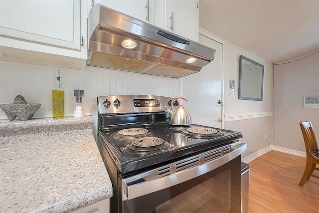 kitchen with light hardwood / wood-style floors, stainless steel electric stove, light stone countertops, and white cabinets