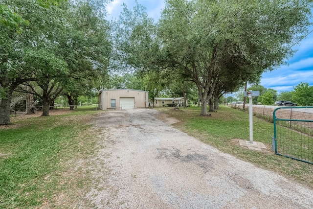 view of front facade featuring a front yard, a garage, and an outbuilding