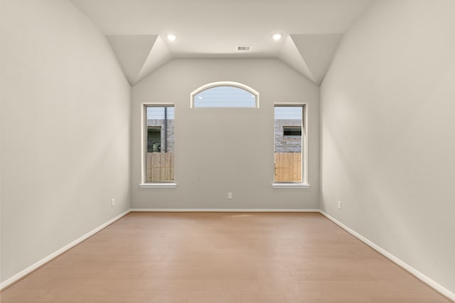 spare room featuring vaulted ceiling and light wood-type flooring