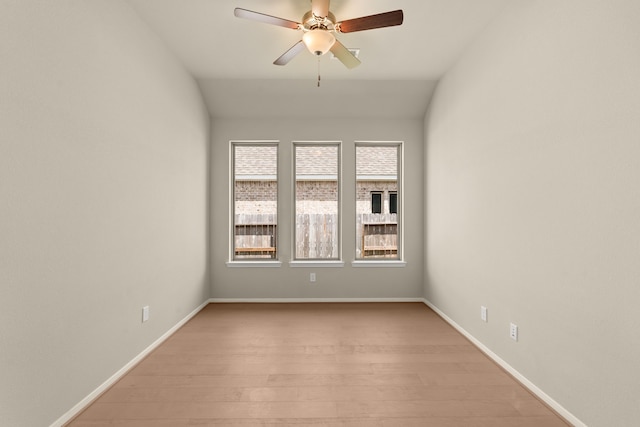 empty room with light hardwood / wood-style flooring, ceiling fan, and vaulted ceiling