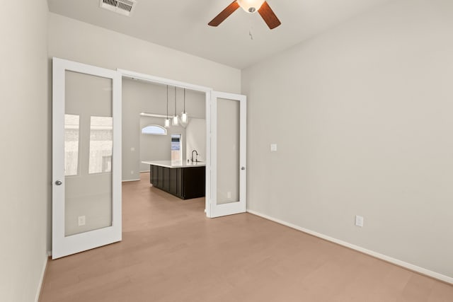 unfurnished bedroom featuring french doors, ceiling fan, sink, and light wood-type flooring