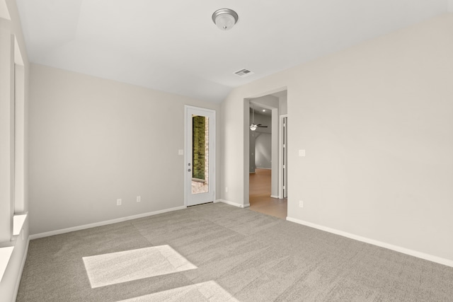 carpeted spare room featuring lofted ceiling