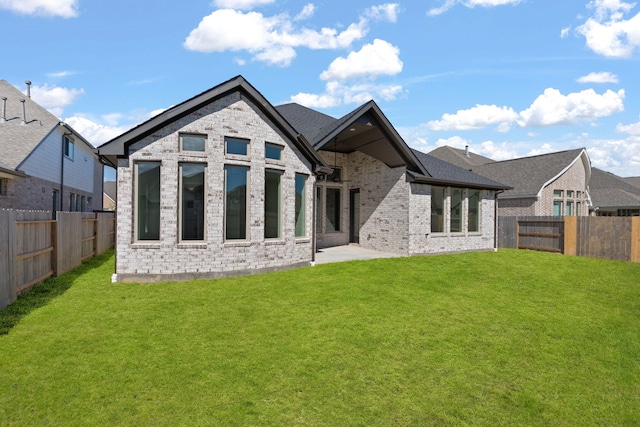 rear view of property with a yard and a patio