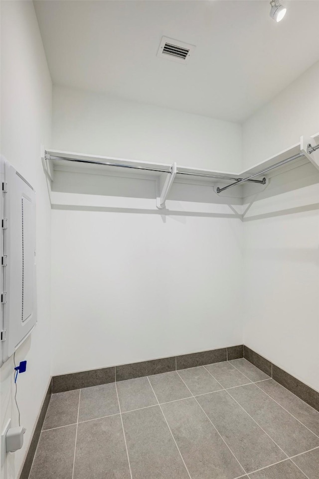 walk in closet featuring visible vents and dark tile patterned floors