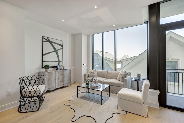 living room with recessed lighting, baseboards, and light wood finished floors