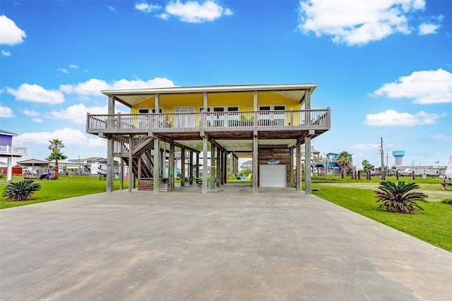 view of front of property featuring a front yard, a carport, and a garage