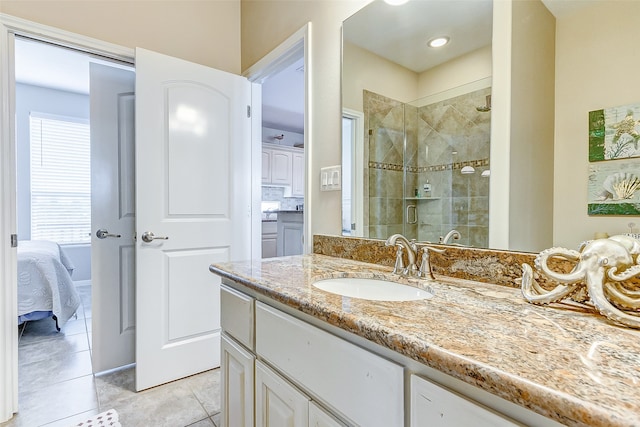 bathroom with a shower with shower door, oversized vanity, and tile flooring