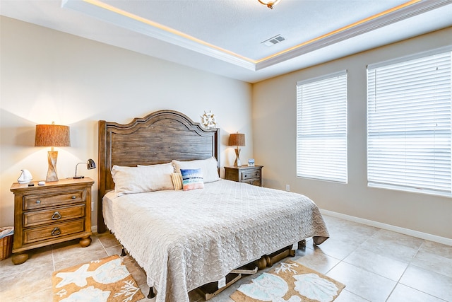 bedroom with a raised ceiling and light tile flooring