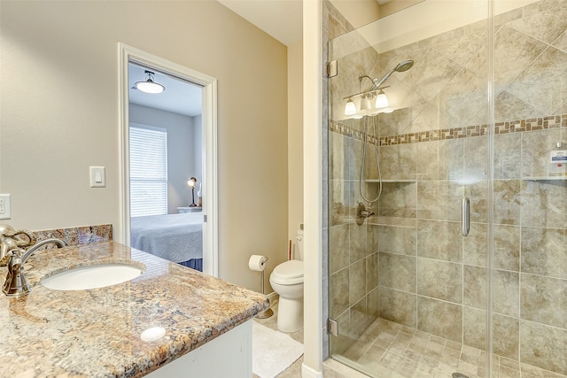 bathroom featuring a shower with door, toilet, and vanity