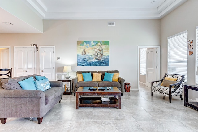 living room featuring tile flooring and a raised ceiling