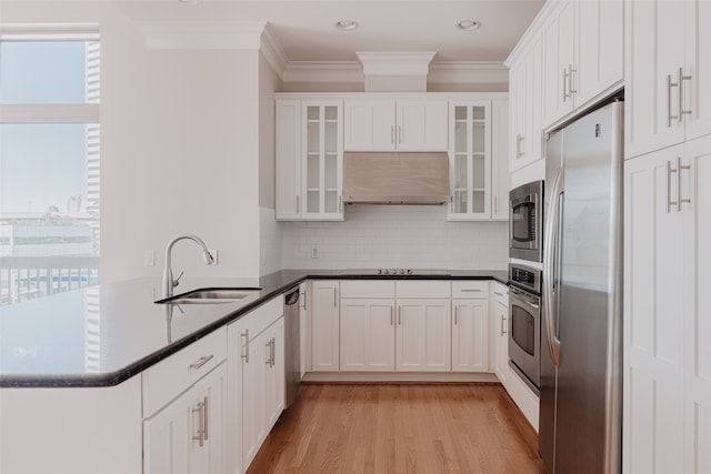 kitchen with sink, light hardwood / wood-style floors, white cabinetry, stainless steel appliances, and premium range hood