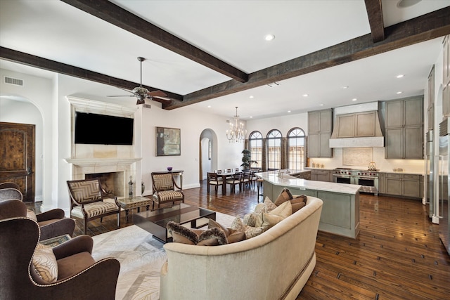 living room with ceiling fan with notable chandelier, dark hardwood / wood-style flooring, and beamed ceiling