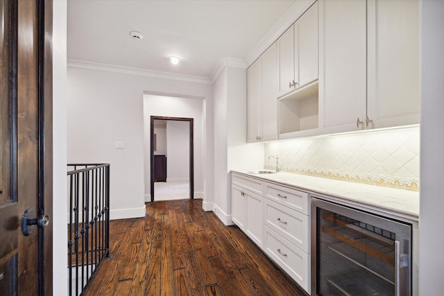 kitchen with backsplash, beverage cooler, light stone counters, white cabinets, and dark hardwood / wood-style flooring