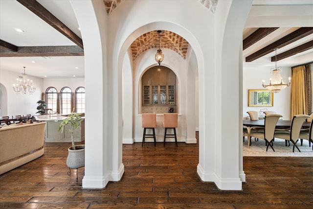 entrance foyer with a chandelier, beamed ceiling, and dark hardwood / wood-style floors