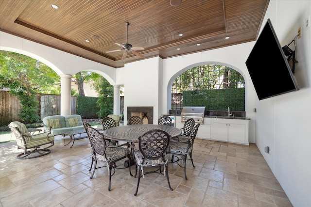 view of patio with ceiling fan, sink, exterior kitchen, a grill, and an outdoor hangout area