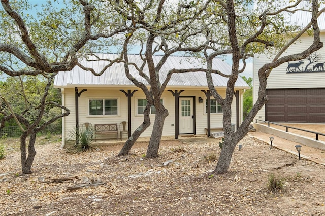 ranch-style house featuring covered porch and a garage