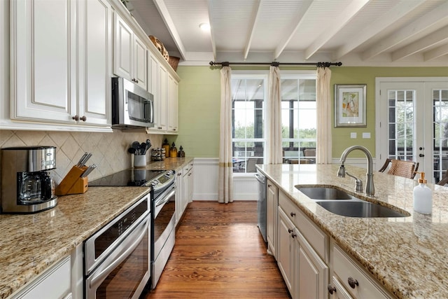 kitchen featuring appliances with stainless steel finishes, light stone counters, beamed ceiling, sink, and dark hardwood / wood-style flooring