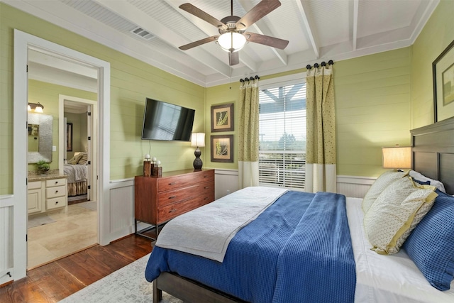 bedroom with beamed ceiling, dark tile flooring, and ceiling fan