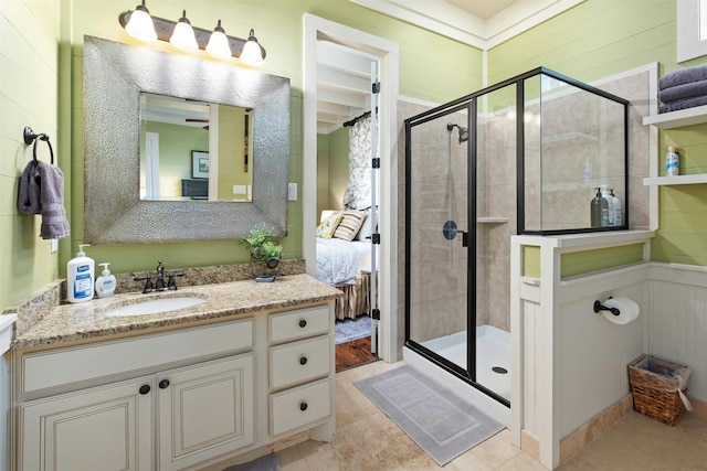 bathroom featuring a shower with shower door, tile floors, and vanity