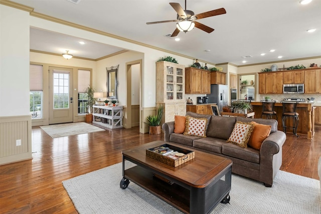 living room featuring ceiling fan, light hardwood / wood-style floors, and crown molding