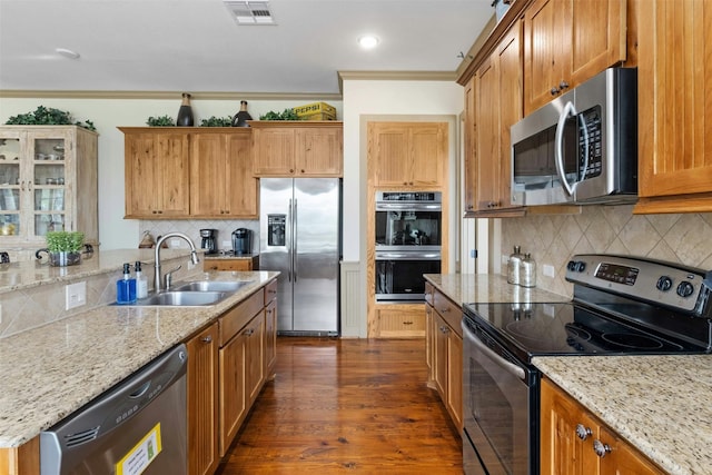 kitchen with appliances with stainless steel finishes, backsplash, crown molding, sink, and dark hardwood / wood-style flooring