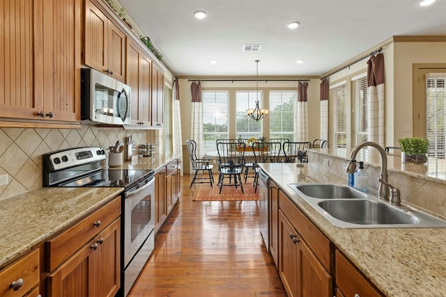 kitchen with hardwood / wood-style floors, sink, appliances with stainless steel finishes, and tasteful backsplash