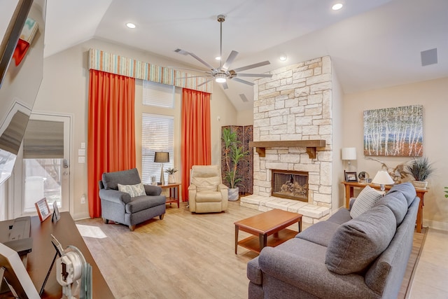 living room with a fireplace, hardwood / wood-style floors, a healthy amount of sunlight, and vaulted ceiling