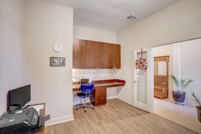 home office featuring built in desk and light wood-type flooring