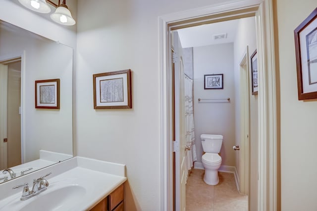 bathroom featuring tile patterned floors, vanity, toilet, and walk in shower