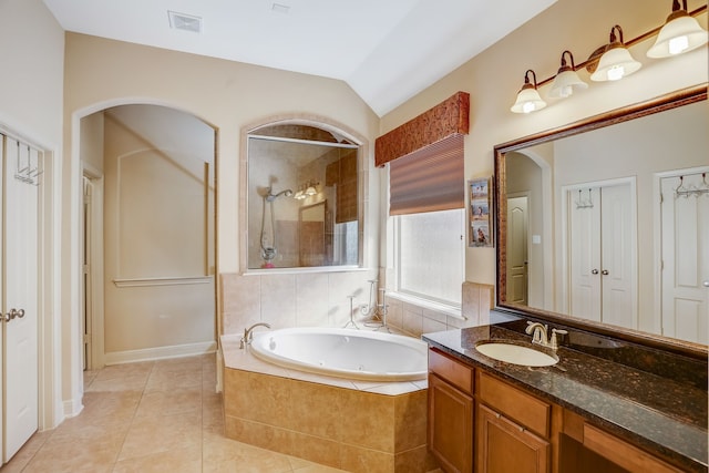 bathroom featuring tile patterned flooring, vanity, plus walk in shower, and vaulted ceiling