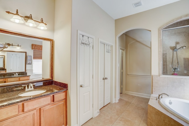 bathroom with plus walk in shower, vanity, and tile patterned flooring