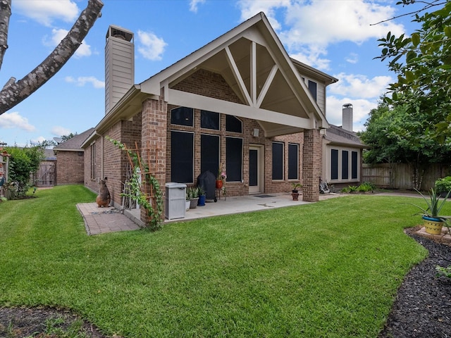 rear view of property featuring a lawn and a patio area