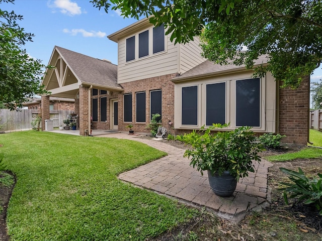 back of house featuring a patio and a yard