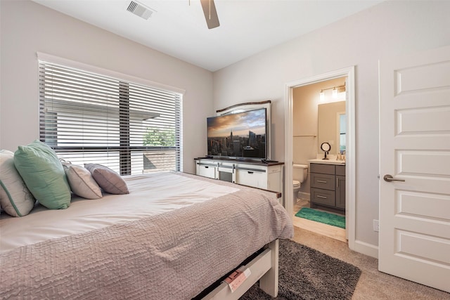 carpeted bedroom featuring connected bathroom and ceiling fan