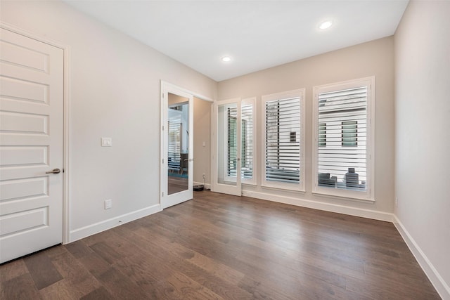 spare room with dark hardwood / wood-style flooring and french doors