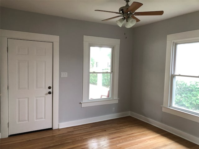 unfurnished room with a wealth of natural light, ceiling fan, and light hardwood / wood-style floors