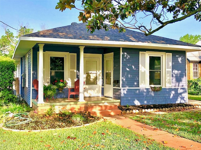 bungalow with a porch and roof with shingles