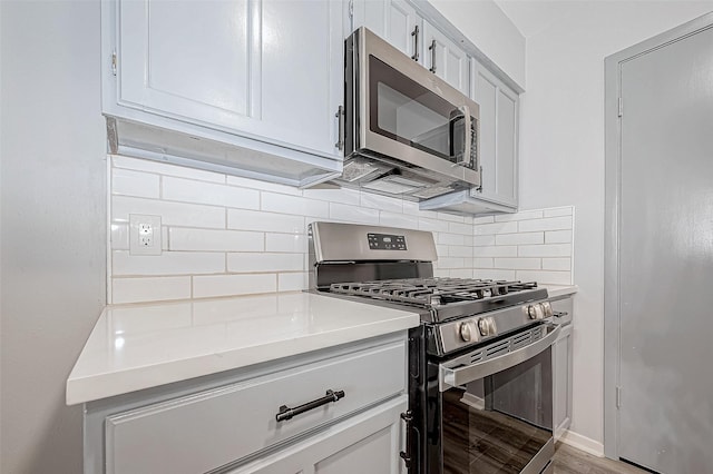 kitchen with tasteful backsplash, light hardwood / wood-style flooring, and appliances with stainless steel finishes