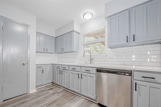 kitchen featuring gray cabinetry, dishwasher, light hardwood / wood-style floors, and sink