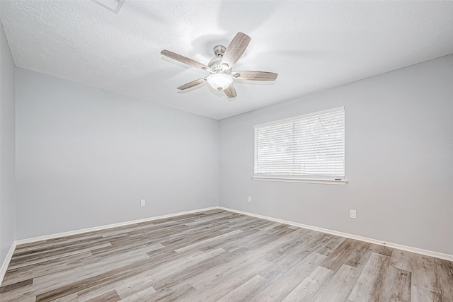 spare room featuring a textured ceiling, light hardwood / wood-style floors, and ceiling fan