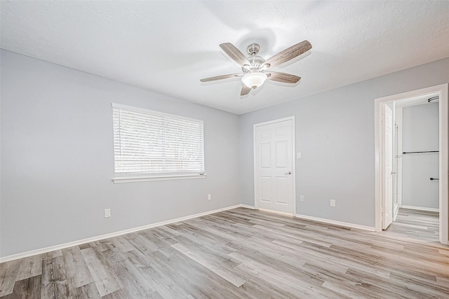 unfurnished bedroom with ceiling fan, light wood-type flooring, and a textured ceiling