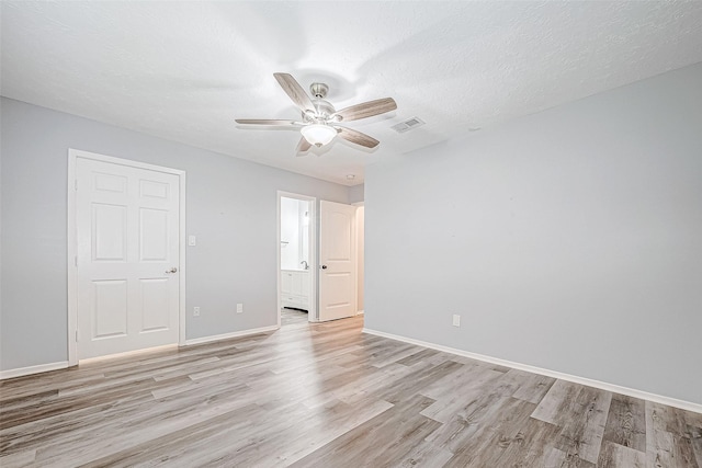 empty room featuring ceiling fan, a textured ceiling, and light hardwood / wood-style flooring