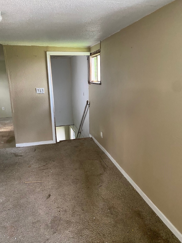 carpeted spare room with a textured ceiling